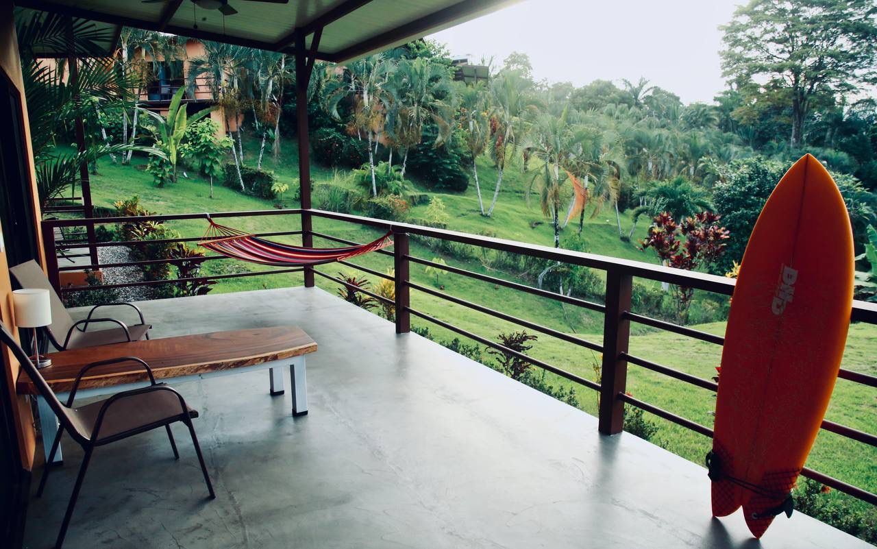 Balcony with hammock, surfboard, and jungle views