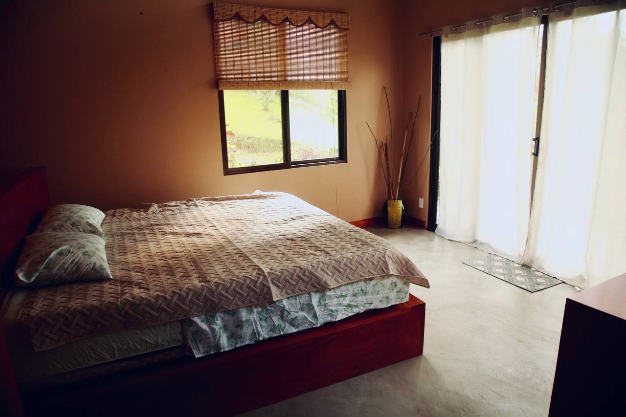 Cozy bedroom with bamboo shades and balcony