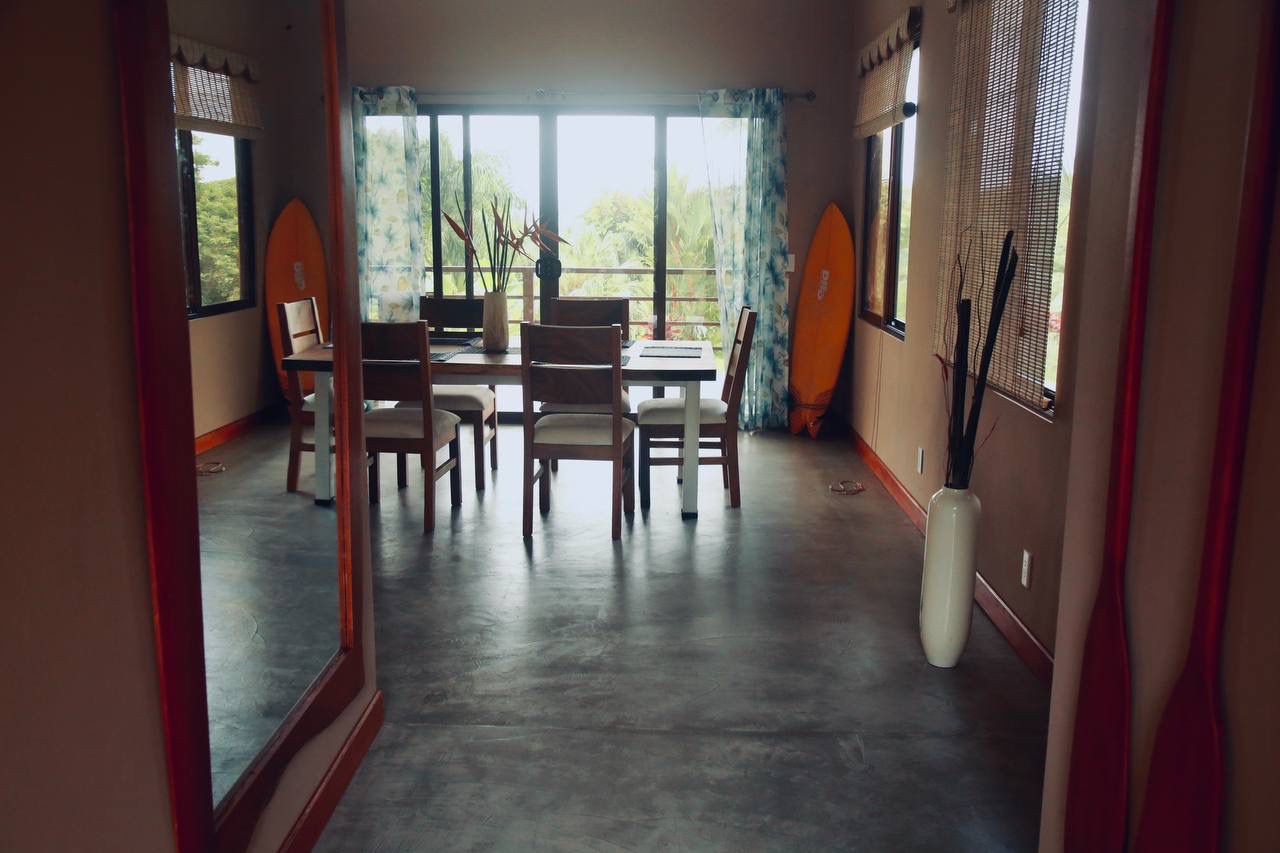 Dining area with surfboards and floor-to-ceiling windows