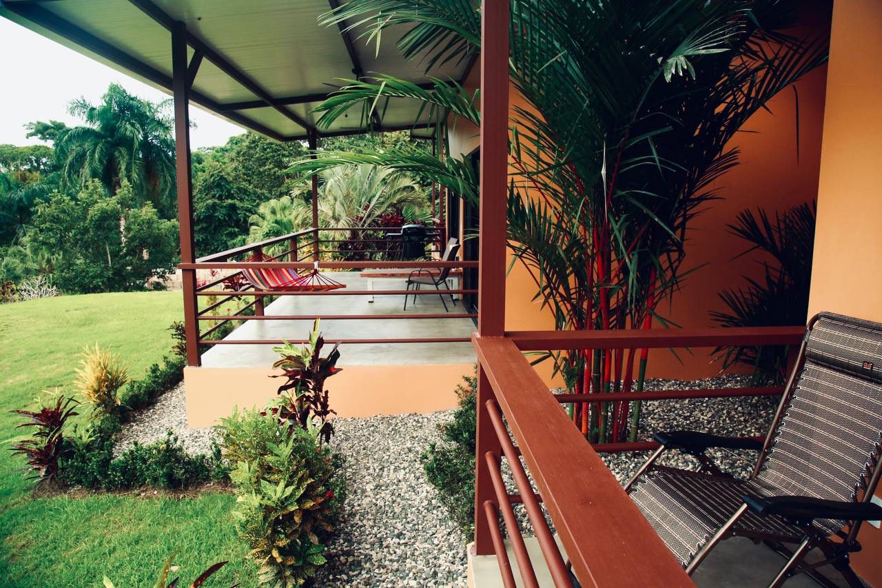 Covered patio with lounge chairs and garden views