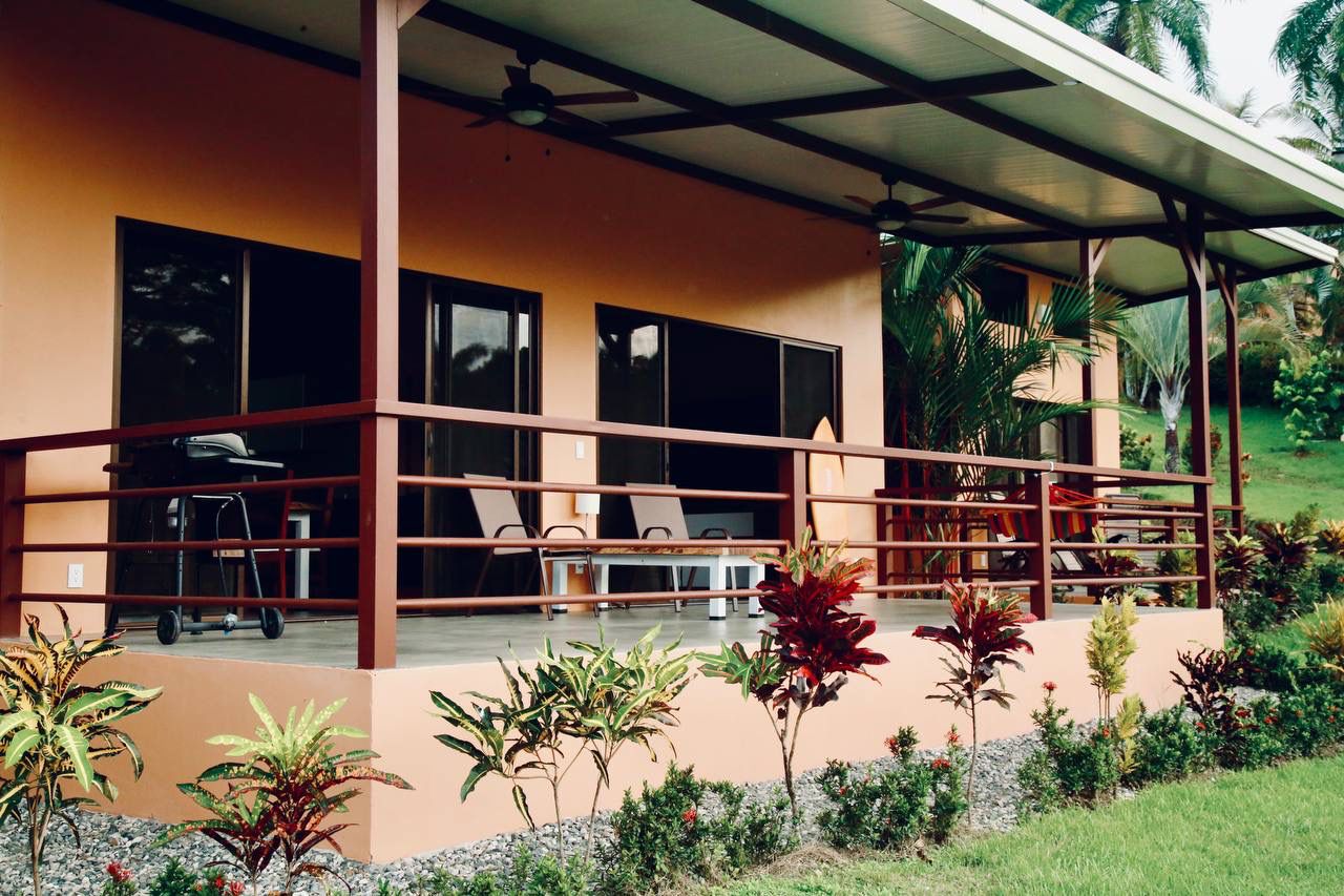 Covered porch with ceiling fans and tropical landscaping